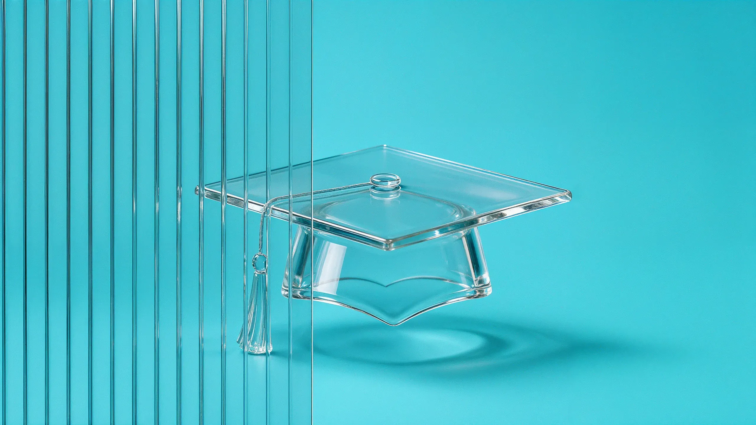 Ein Doktorhut aus klarem Glas schwebt vor türkisem Hintergrund, die Quaste hängt seitlich herab; links steht eine Scheibe aus Riffelglas, hinter der sich der Hut bricht