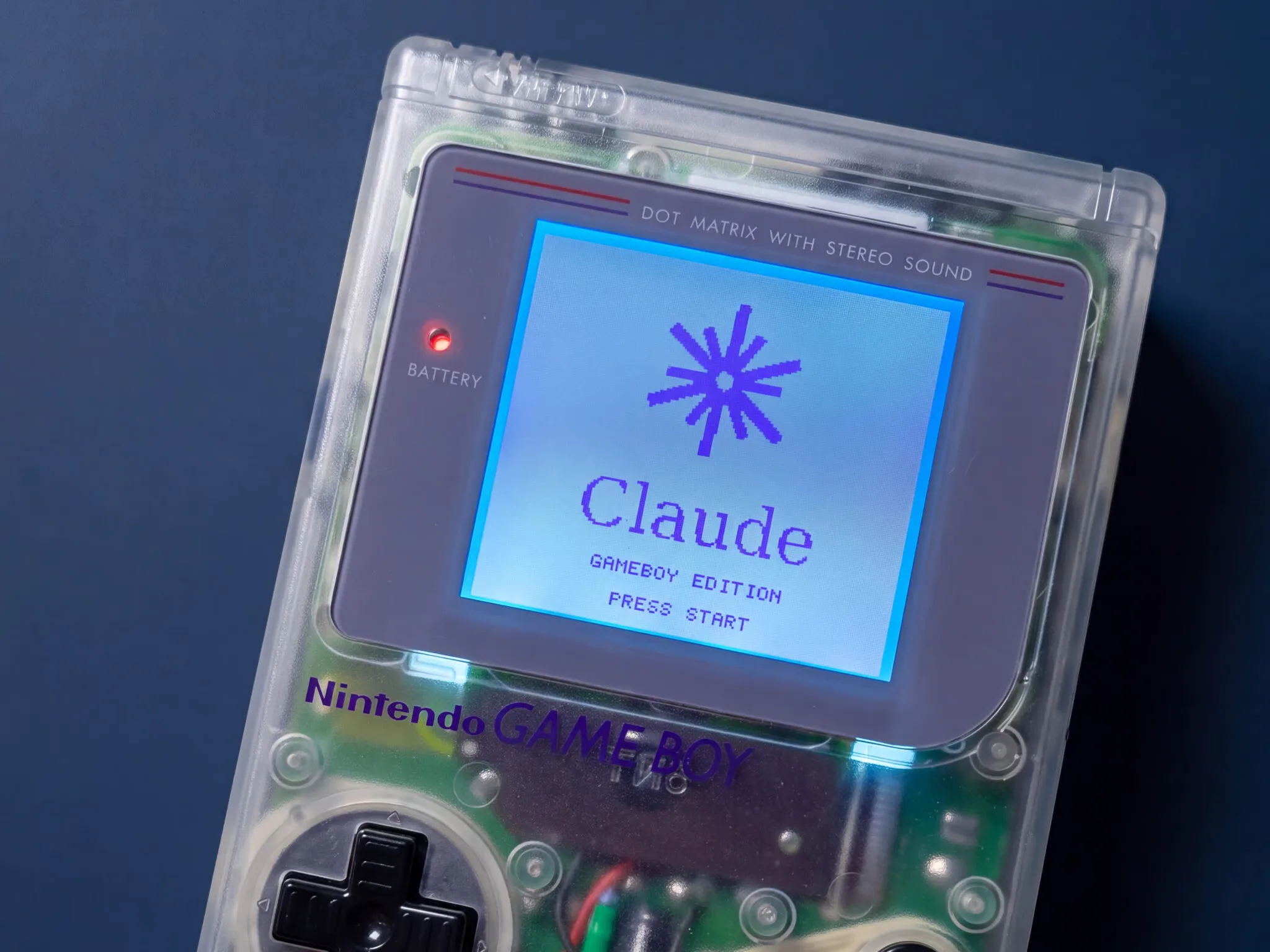 Ein transparenter Game Boy zeigt den Startbildschirm „Claude · Gameboy Edition“