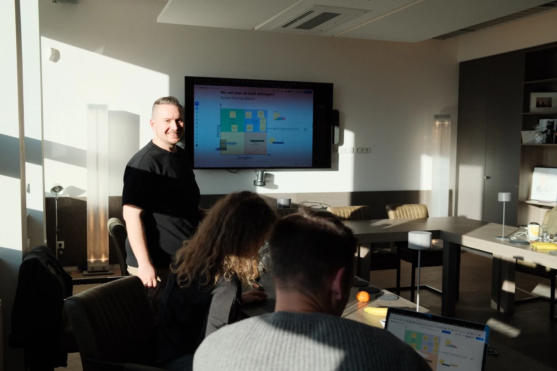Georg Neumann begleitet ein Team bei einem KI-Praxis-Workshop